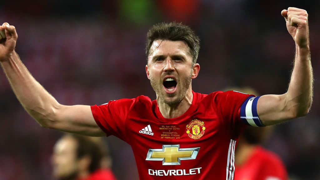 Michael Carrick in Manchester United kit during a Premier League match, celebrating on the pitch