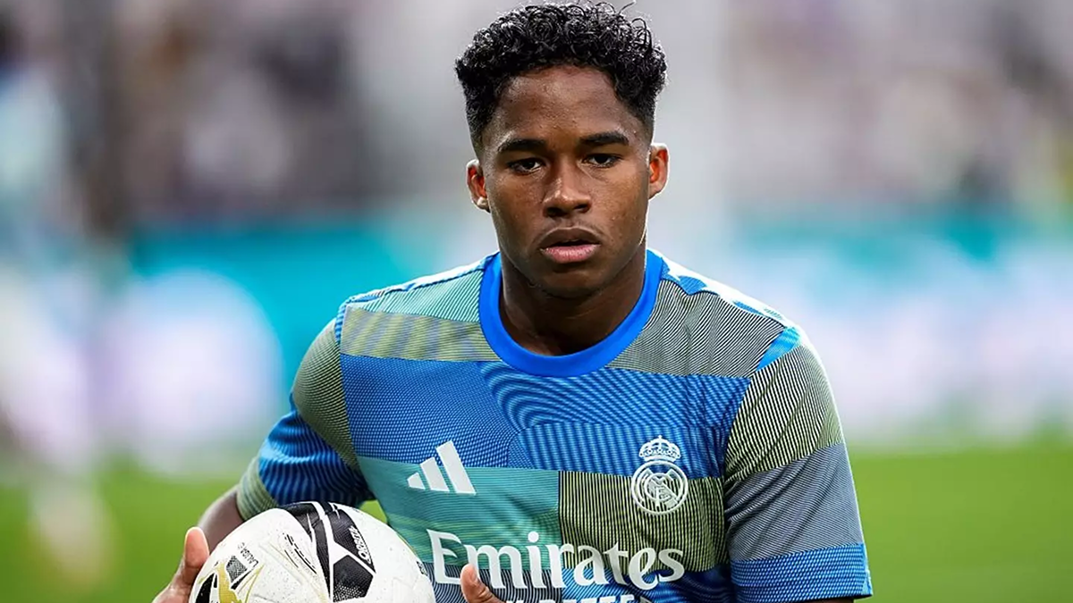 Endrick holding the ball in Real Madrid kit, ready to attack during a match.
