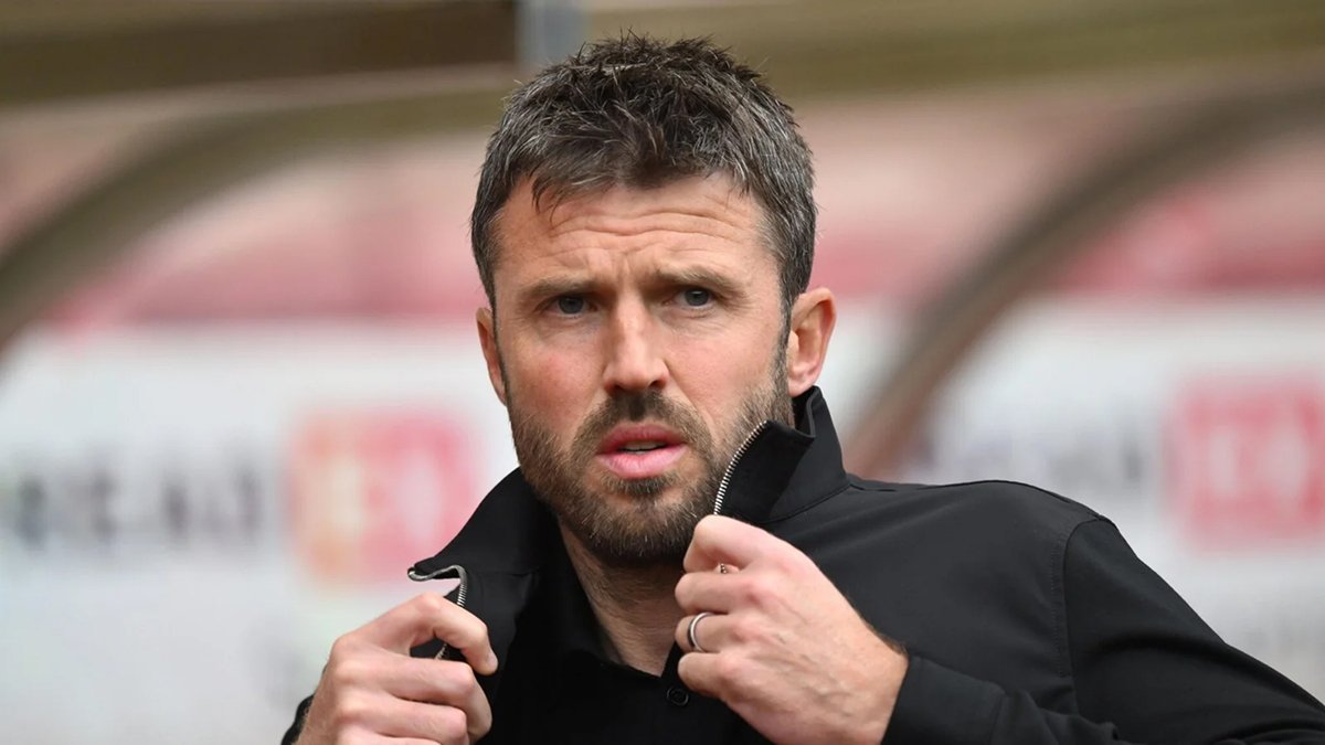 Michael Carrick focused on the pitch at Old Trafford during a match, representing Manchester United leadership.