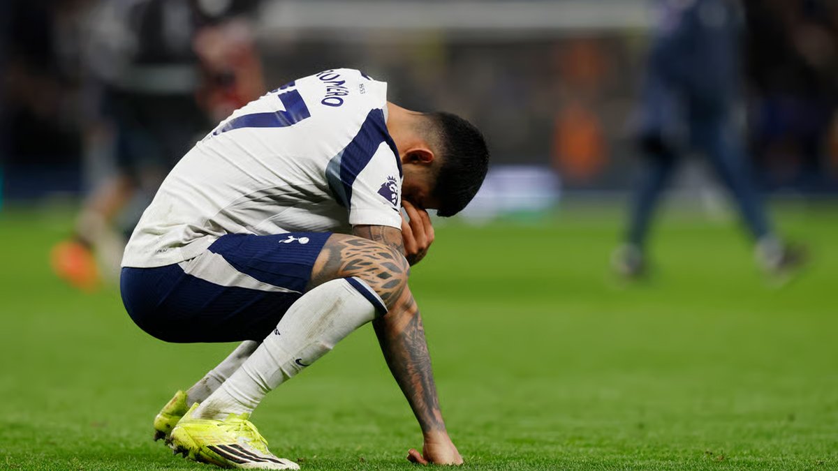 Tottenham player crouches on the pitch with head down