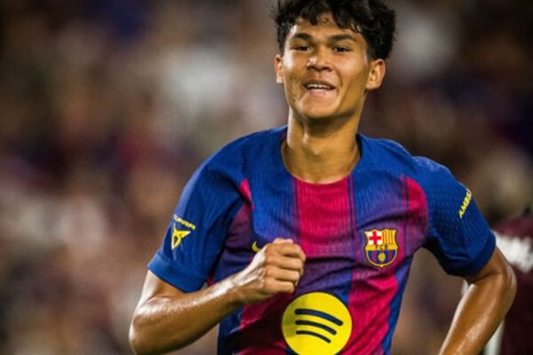 Young Barcelona midfielder celebrates in home kit during a night match