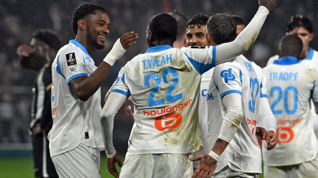 Marseille players huddle after scoring, Angers defenders regroup nearby