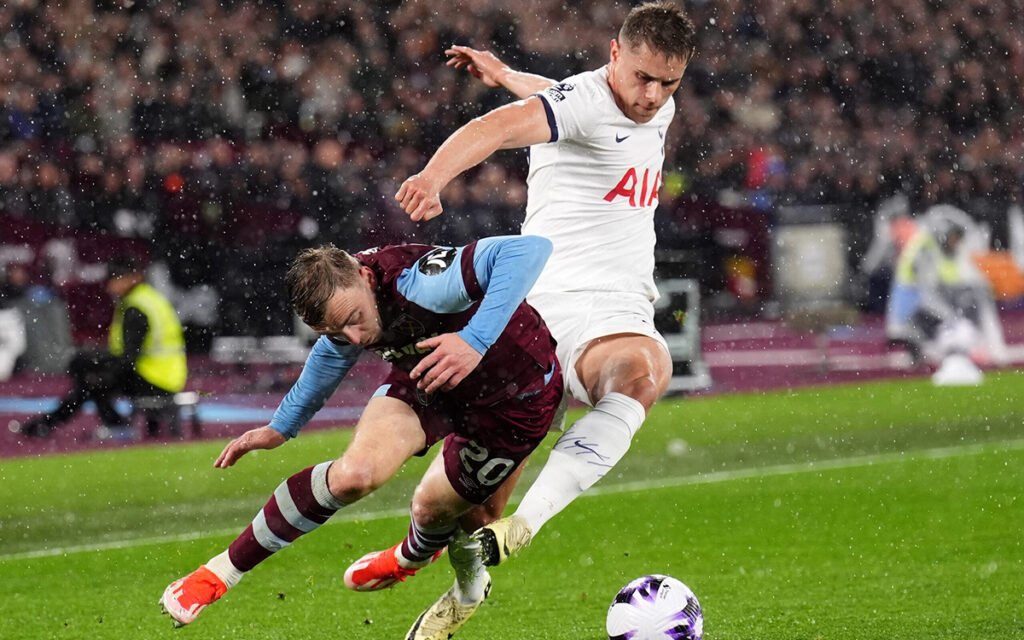 Tottenham and West Ham players tussle for the ball in rainy conditions