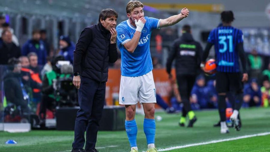 Napoli coaching staff talks with Hojlund on the touchline during a game