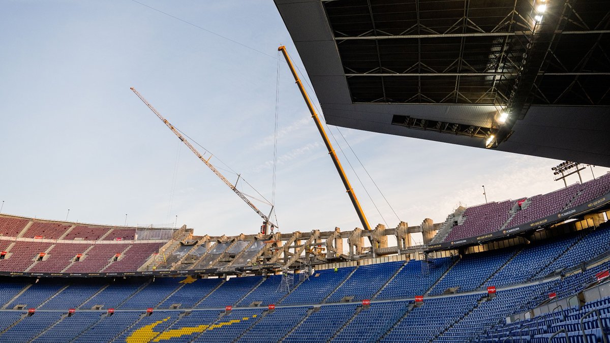 Partially renovated Camp Nou with cranes and roof structure above stands