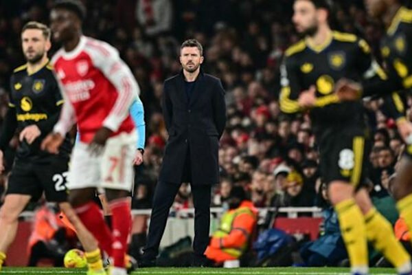 Michael Carrick watches from the touchline during a night match