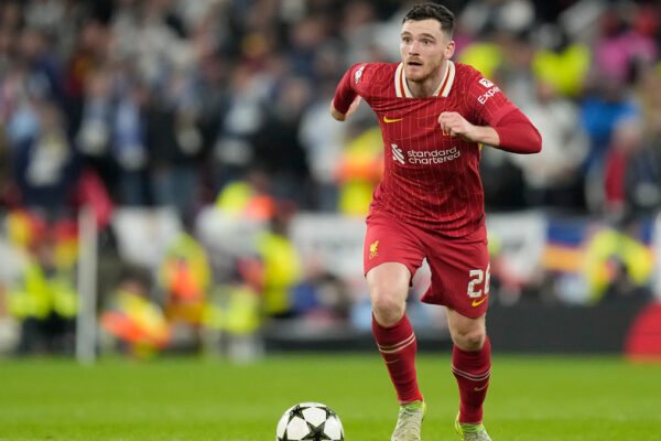 Andy Robertson runs with the ball in Liverpool red kit