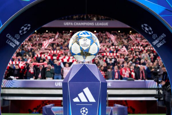Champions League ball on grass under bright stadium floodlights