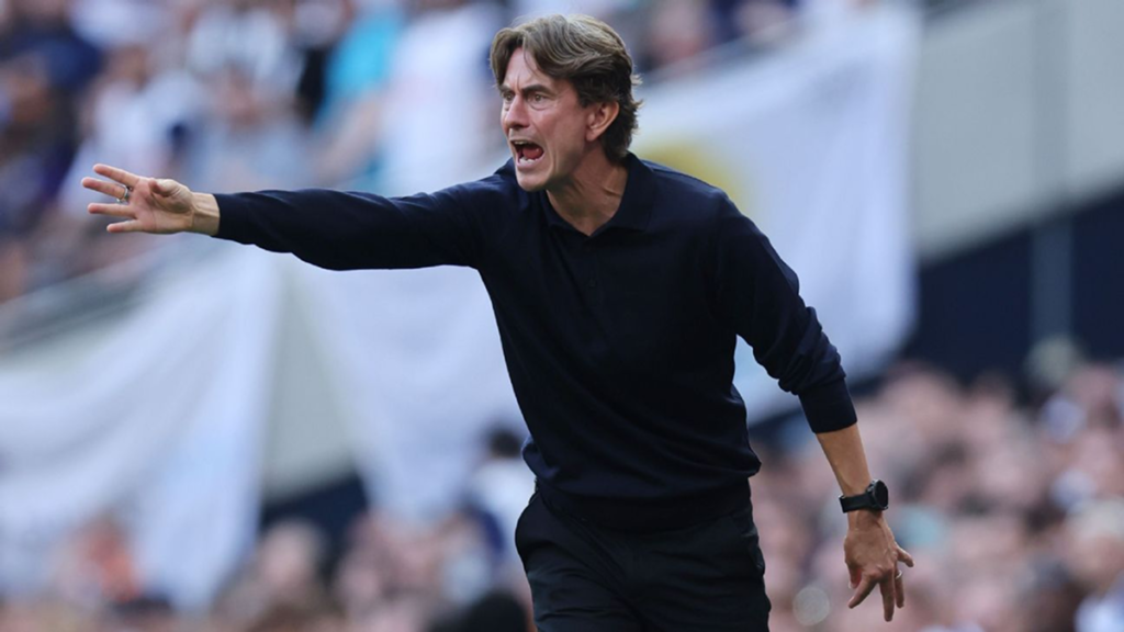 Tottenham head coach watching the match from the bench with a focused expression