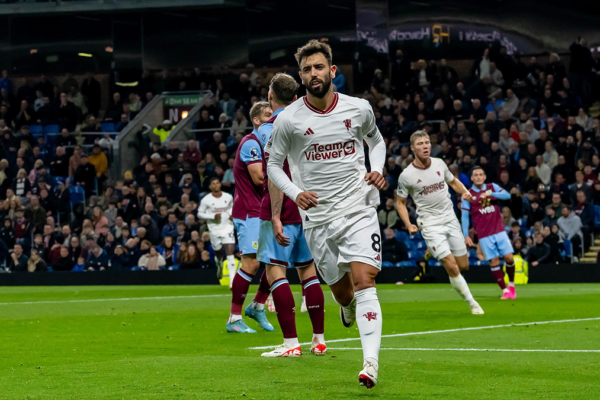 Bruno Fernandes scoring a goal and starting to celebrate during a Manchester United match.