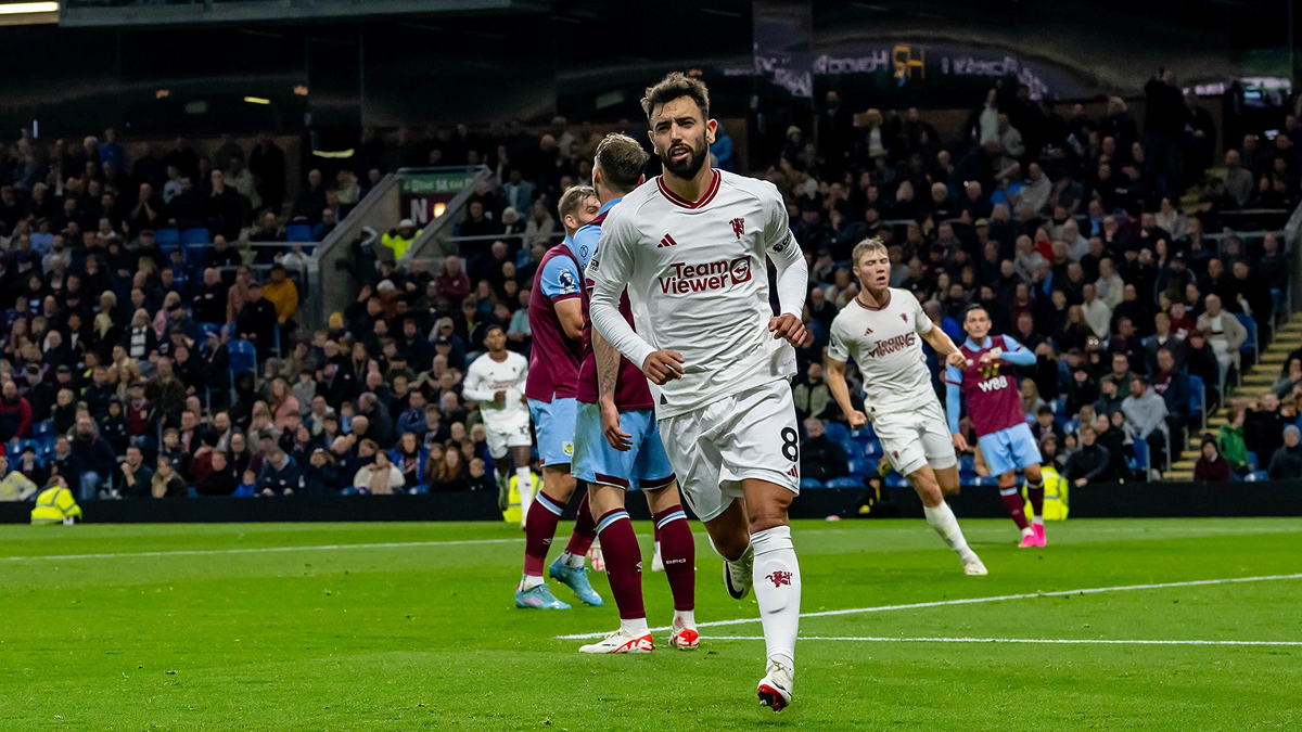 Bruno Fernandes scoring a goal and starting to celebrate during a Manchester United match.