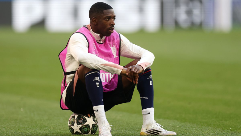 Ousmane Dembélé sitting on the ball during PSG training, focused and reflective, solo shot