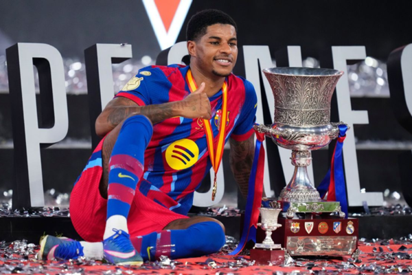 Marcus Rashford celebrates Barcelona’s Spanish Supercopa victory with the trophy