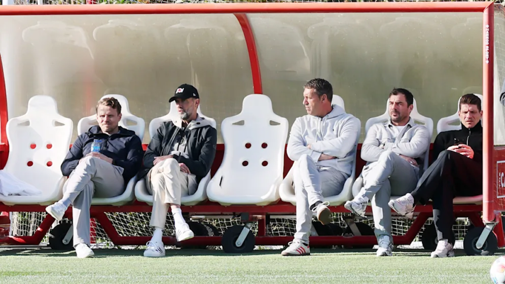 Jürgen Klopp discussing tactics with RB Leipzig staff and coaches while sitting on the bench
