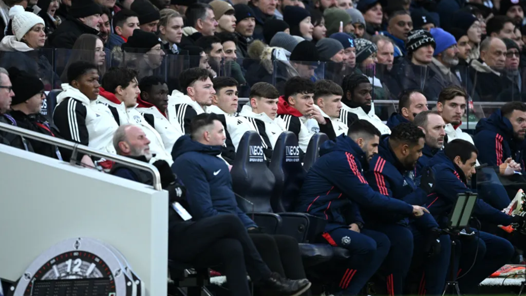 Manchester United bench during a match, showing Darren Fletcher and coaching staff observing the game