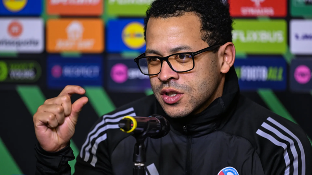 Strasbourg manager Liam Rosenior reacting to live gameplay, showing concentration and tactical awareness.