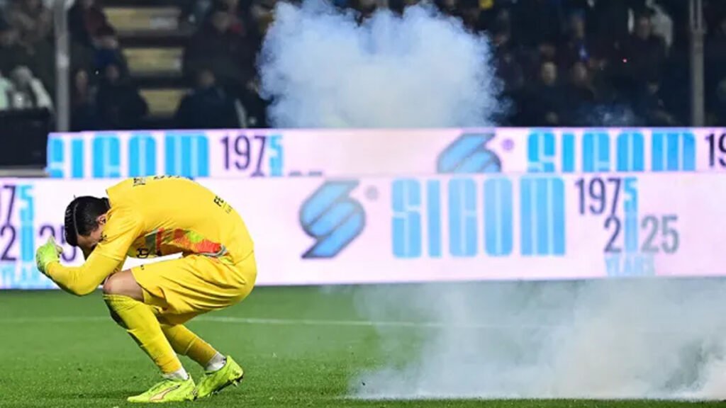 Medical staff check Emil Audero after a flare lands in the box