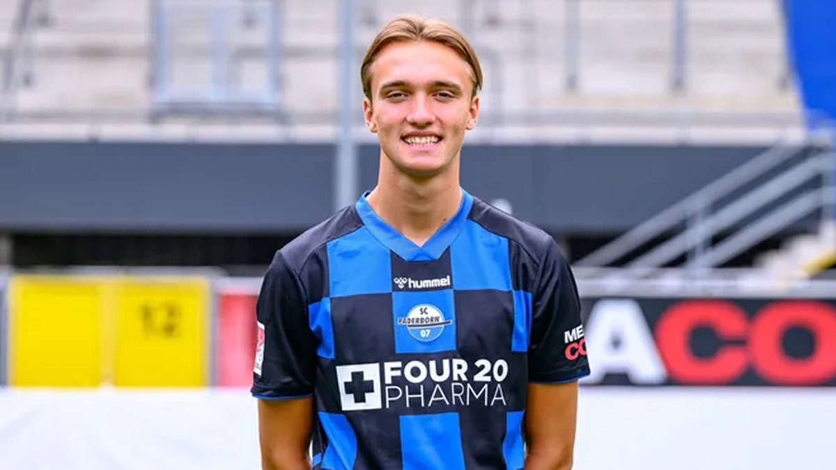 Young midfielder holds Hoffenheim scarf during club signing moment