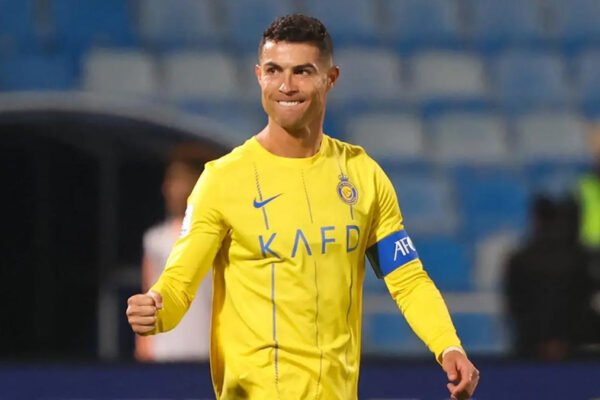 Cristiano Ronaldo celebrates in yellow kit under stadium floodlights