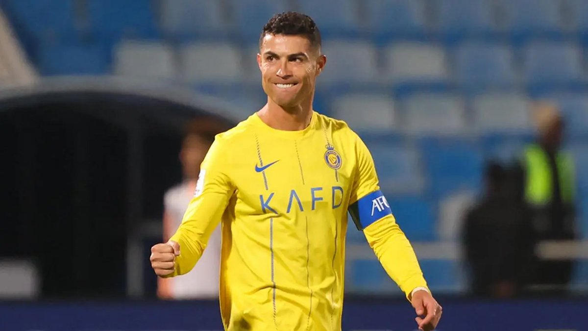 Cristiano Ronaldo celebrates in yellow kit under stadium floodlights