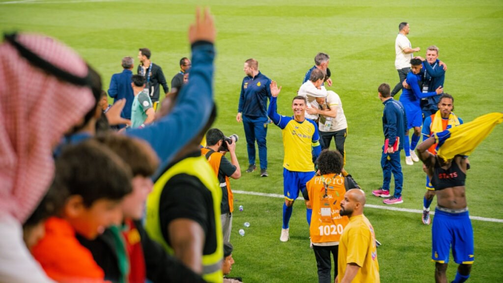 Cristiano Ronaldo in yellow kit waves to fans after match