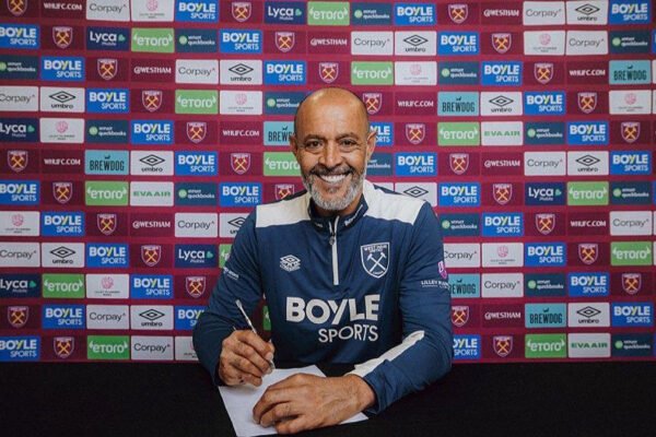 Nuno Espírito Santo signs paperwork after being appointed head coach.