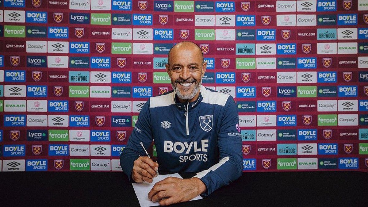 Nuno Espírito Santo signs paperwork after being appointed head coach.