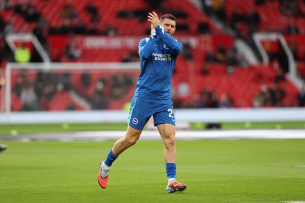 James Milner warms up on the touchline in Brighton colours before coming on as a substitute.