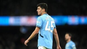 Khusanov challenges for the ball in Manchester City colours during a Premier League match.