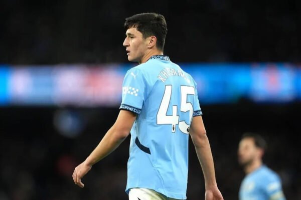 Khusanov challenges for the ball in Manchester City colours during a Premier League match.