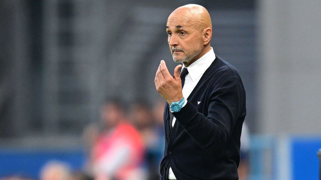 Luciano Spalletti watches from the touchline during a match, arms folded and focused.