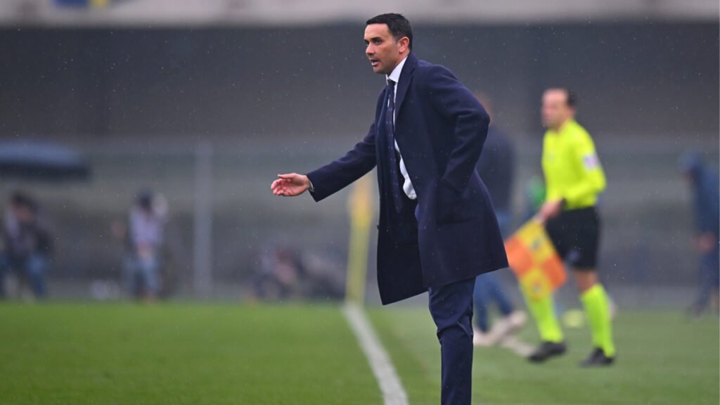 Coach on the touchline giving instructions to players